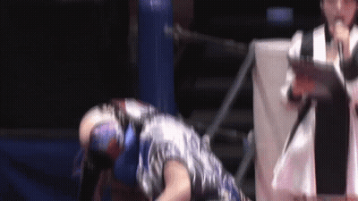A Man In A Mask Is Laying On The Ground In A Wrestling Ring GIF