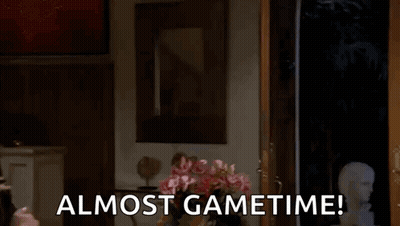A Man In A Mask Is Peeking Out Of A Door With The Words Almost Gametime Below Him GIF