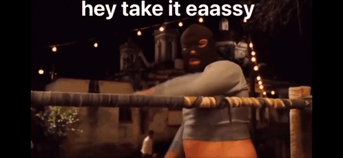 A Man In A Mask Is Standing In A Boxing Ring With The Caption Hey Take It Eaassy GIF