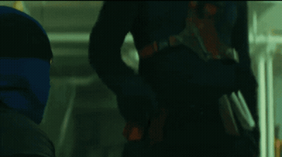 A Man In A Mask Is Standing In A Dark Room With The Word Poser Written Above Him GIF