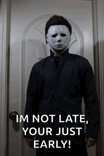 A Man In A Mask Is Standing In Front Of A Door And Says " Im Not Late Your Just Early " GIF