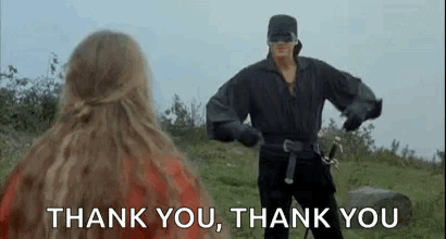 A Man In A Mask Is Standing In Front Of A Woman And Saying `` Thank You , Thank You '' . GIF