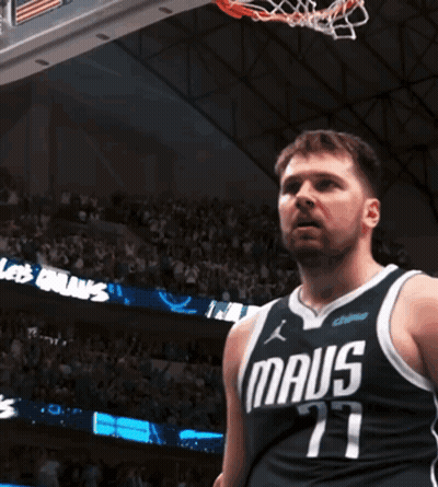 A Man In A Maus Jersey Stands In Front Of A Basketball Hoop GIF