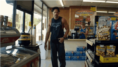 A Man In A Metallica Shirt Is Standing In Front Of A Candy Express Store GIF