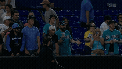 A Man In A Miami Jersey Talks To Another Man In The Stands GIF