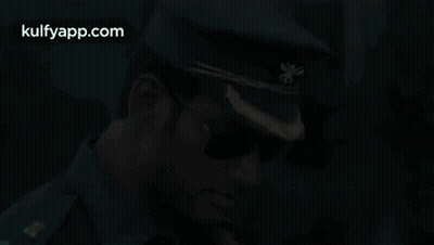A Man In A Military Uniform And Sunglasses Is Wearing A Hat . GIF