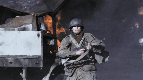 A Man In A Military Uniform Holding A Gun With The Letters U.s.a. On It GIF