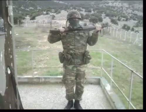 Man In Military Uniform Holding Gun GIF