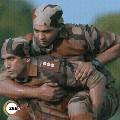 A Man In A Military Uniform Is Carrying Another Man On His Shoulders GIF