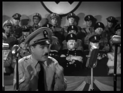 A Man In A Military Uniform Is Giving A Speech In Front Of A Crowd Of Soldiers . GIF