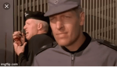 A Man In A Military Uniform Is Looking At Another Man GIF