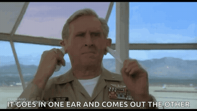 A Man In A Military Uniform Is Plugging His Ears In A Movie Scene . GIF