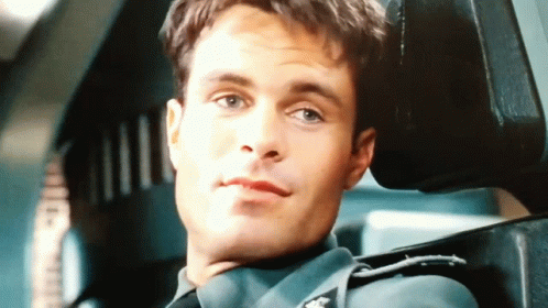 A Man In A Military Uniform Is Sitting In A Chair With His Head Resting On The Back Of The Chair . GIF