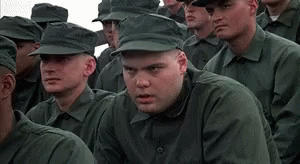 A Man In A Military Uniform Is Sitting In A Row Of Soldiers . GIF