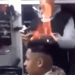 A Man In A Military Uniform Is Sitting In Front Of A Mirror With A Fireball Coming Out Of His Head . GIF