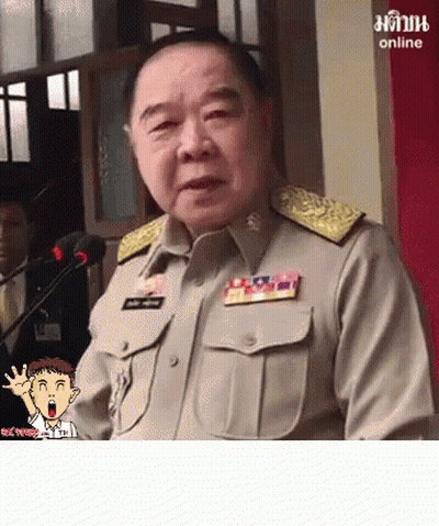 A Man In A Military Uniform Is Speaking Into A Microphone With A Cartoon Character Behind Him That Says Online On The Bo GIF