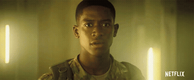 a man in a military uniform is standing in a dark room with a netflix logo in the corner .