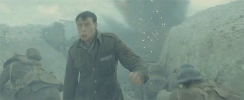 A Man In A Military Uniform Is Standing In A Trench . GIF