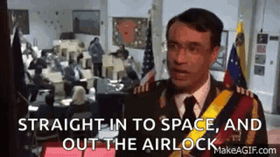 A Man In A Military Uniform Is Standing In Front Of A Crowd Of People In A Room . GIF