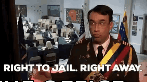 A Man In A Military Uniform Is Standing In Front Of A Group Of People In A Room . GIF