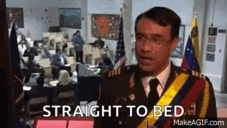 A Man In A Military Uniform Is Standing In Front Of A Group Of People In An Office . GIF
