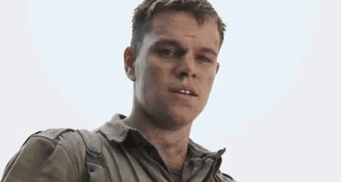 A Man In A Military Uniform Is Standing In Front Of A White Background . GIF