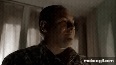 A Man In A Military Uniform Is Standing In Front Of A Window In A Room . GIF