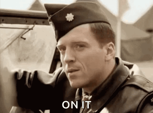 A Man In A Military Uniform Is Standing Next To A Car And Saying On It . GIF