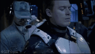 A Man In A Military Uniform Is Standing Next To Another Man Wearing Headphones And A Hat With A Military Logo On It GIF
