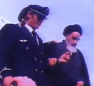 A Man In A Military Uniform Is Standing Next To Another Man With A Beard GIF
