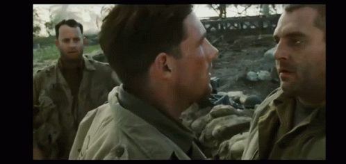 A Man In A Military Uniform Is Talking To Another Man In A Field . GIF