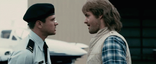 A Man In A Military Uniform Is Talking To Another Man In A Plaid Shirt GIF