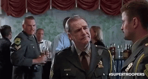 A Man In A Military Uniform Is Talking To Another Man In A Room . GIF