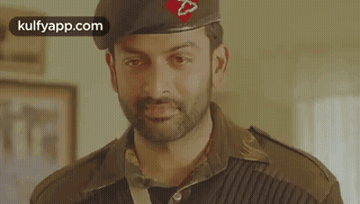 A Man In A Military Uniform Is Wearing A Beret And Looking At The Camera . GIF