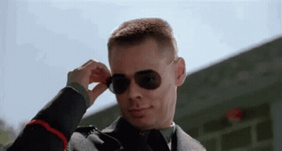 A Man In A Military Uniform Is Wearing Sunglasses And Adjusting His Sunglasses . GIF