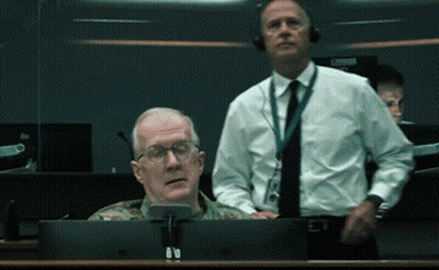 A Man In A Military Uniform Sits In Front Of A Computer Screen GIF