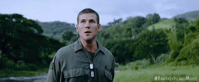 A Man In A Military Uniform Stands In A Field With Trees In The Background And A #Fantasyislandmovie Hashtag GIF