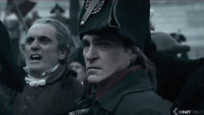 A Man In A Military Uniform Stands In Front Of A Crowd With The Words Kinocheck On The Bottom Left GIF