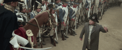 A Man In A Military Uniform Stands In Front Of A Line Of Soldiers And A Horse GIF