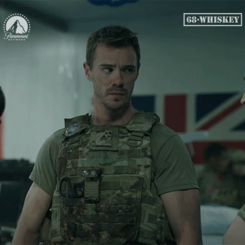 A Man In A Military Uniform Stands In Front Of A Sign That Says 68 Whiskey GIF