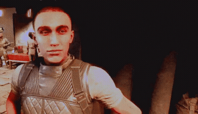A Man In A Military Uniform With A Backpack Looks At The Camera GIF