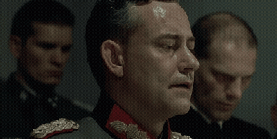 A Man In A Military Uniform With A Red Collar And A Silver Eagle On It GIF