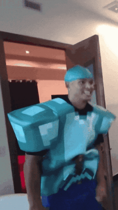 A Man In A Minecraft Costume Is Standing In A Room GIF