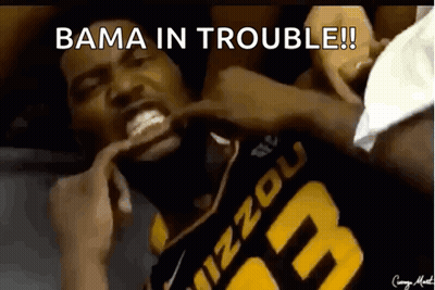 a man in a mizzou jersey is laying on the ground