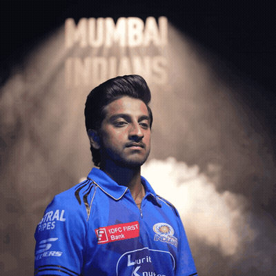 A Man In A Mumbai Indians Shirt Stands In Front Of A Sign That Says Mumbai Indians GIF