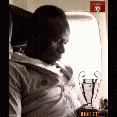 A Man In A New Balance Jacket Is Holding A Trophy GIF