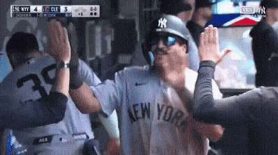 A Man In A New York Yankees Jersey High Fives Another Man GIF