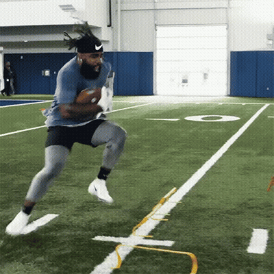 A Man In A Nike Headband Runs With A Football GIF