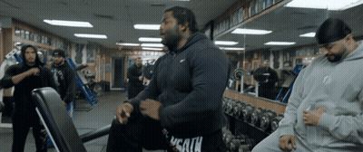 A Man In A Nike Hoodie Sits On A Bench GIF