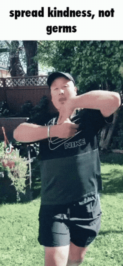 A Man In A Nike Shirt Is Dancing In A Park GIF